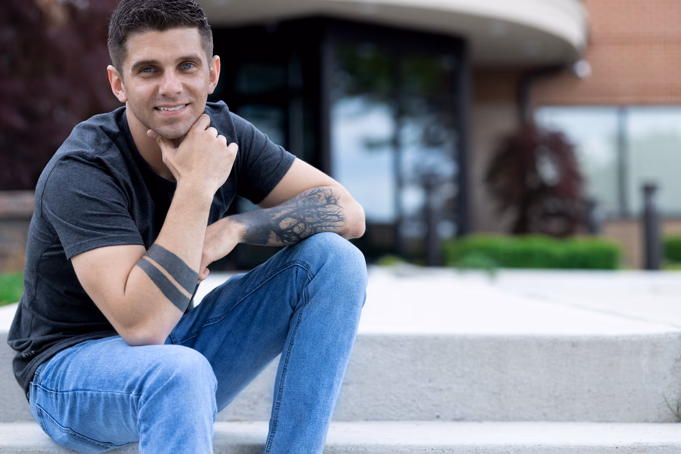Corey, owner of Cuyahoga Falls Business IT, sitting on the front steps outside a local office building.